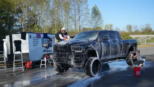 Lifted black Ram HD covered in foam during a hand wash